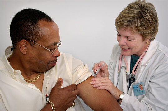 Male receiving a shot from a medical professional